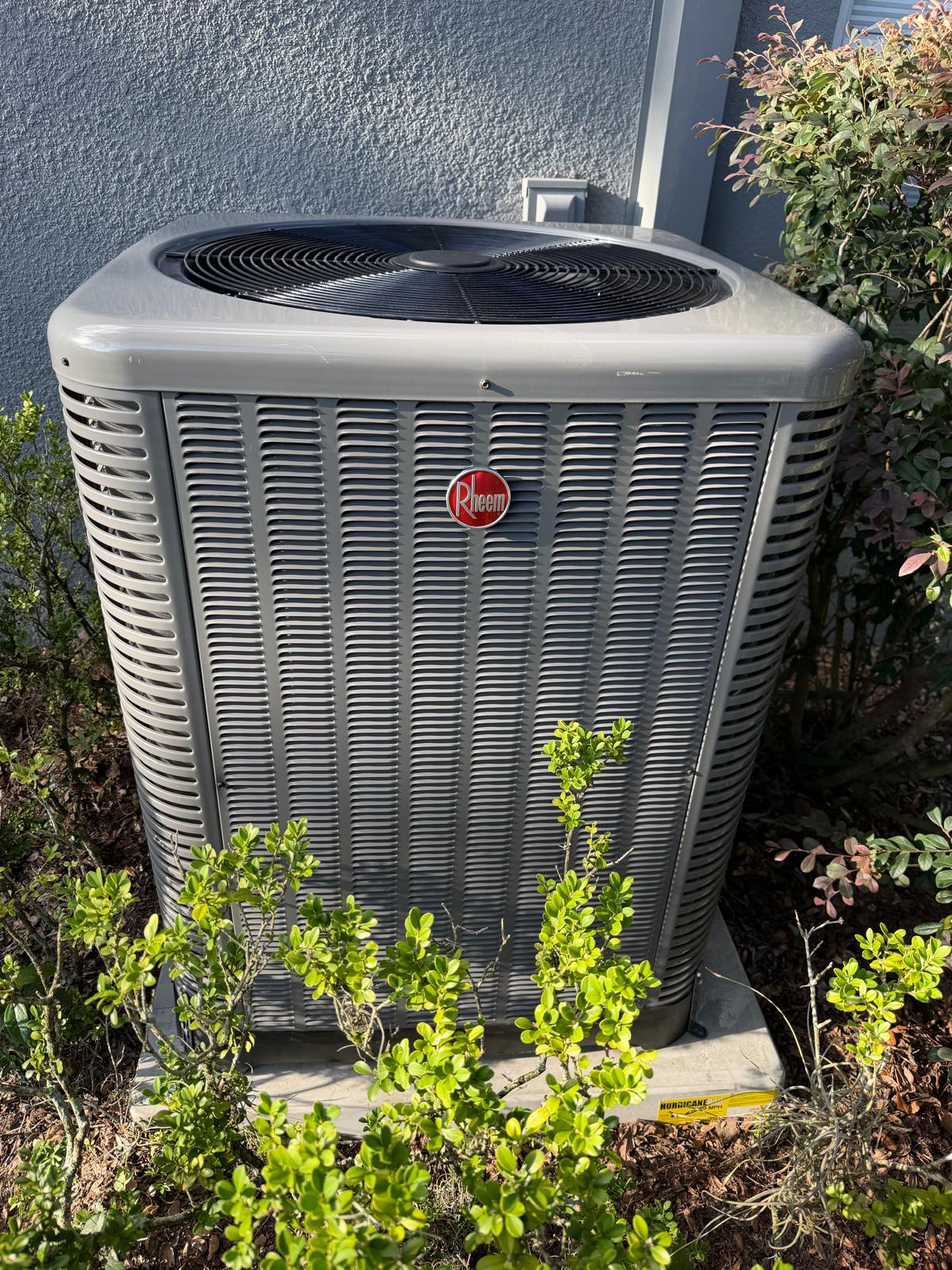 New Rheem condenser installed beside a home