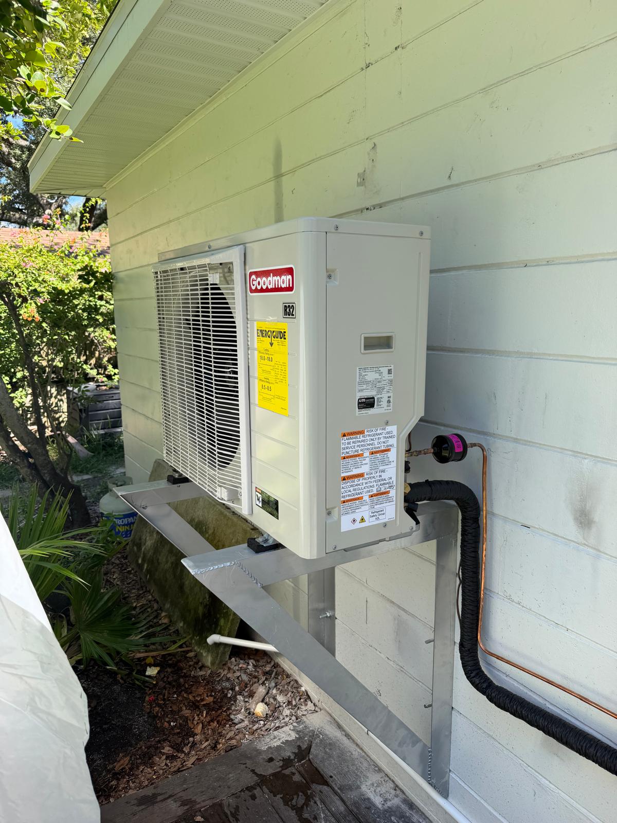 New Goodman mini split outdoor unit mounted on the side of a home
