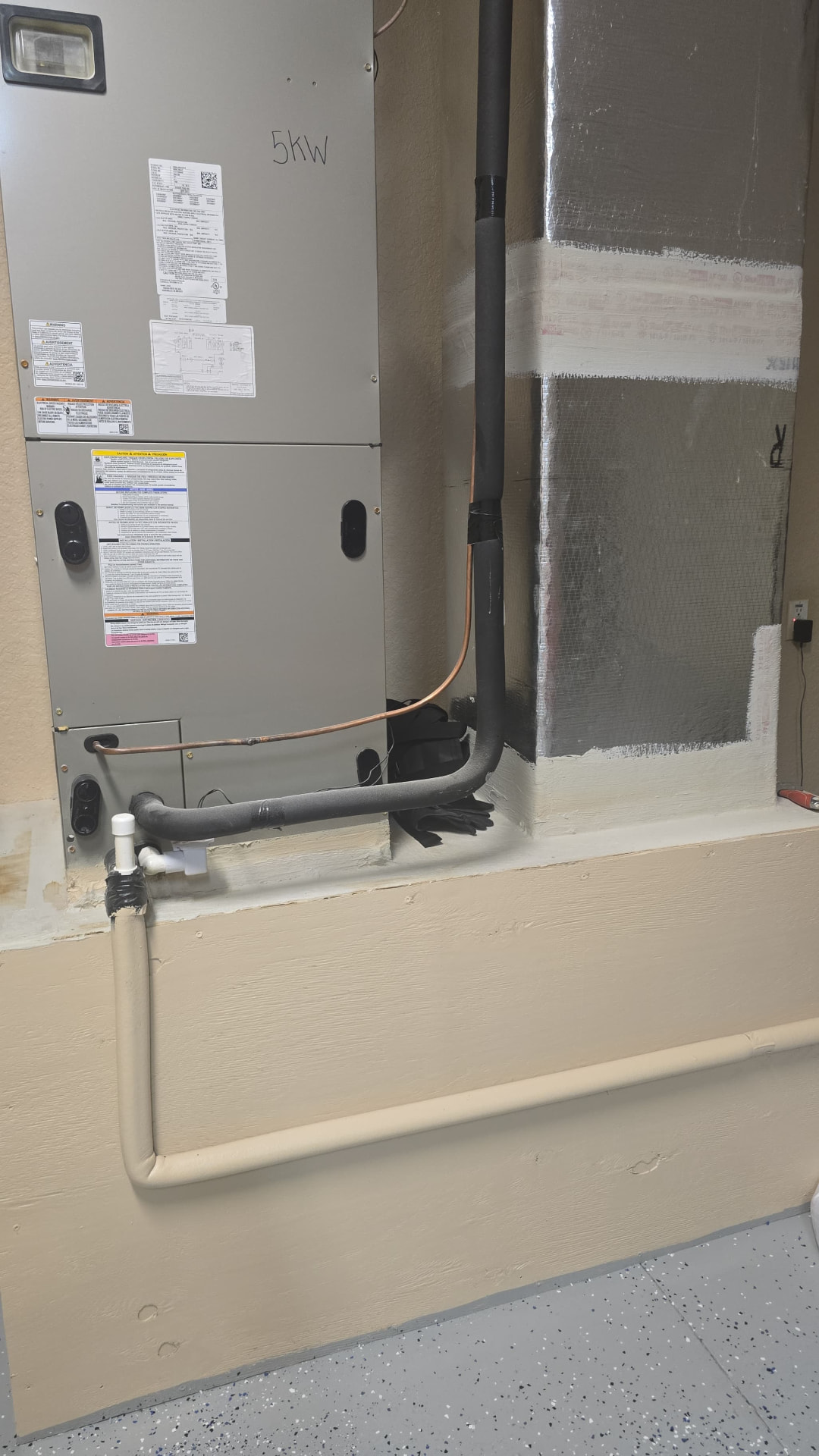 Air handler with new refrigerant line set installed in a garage